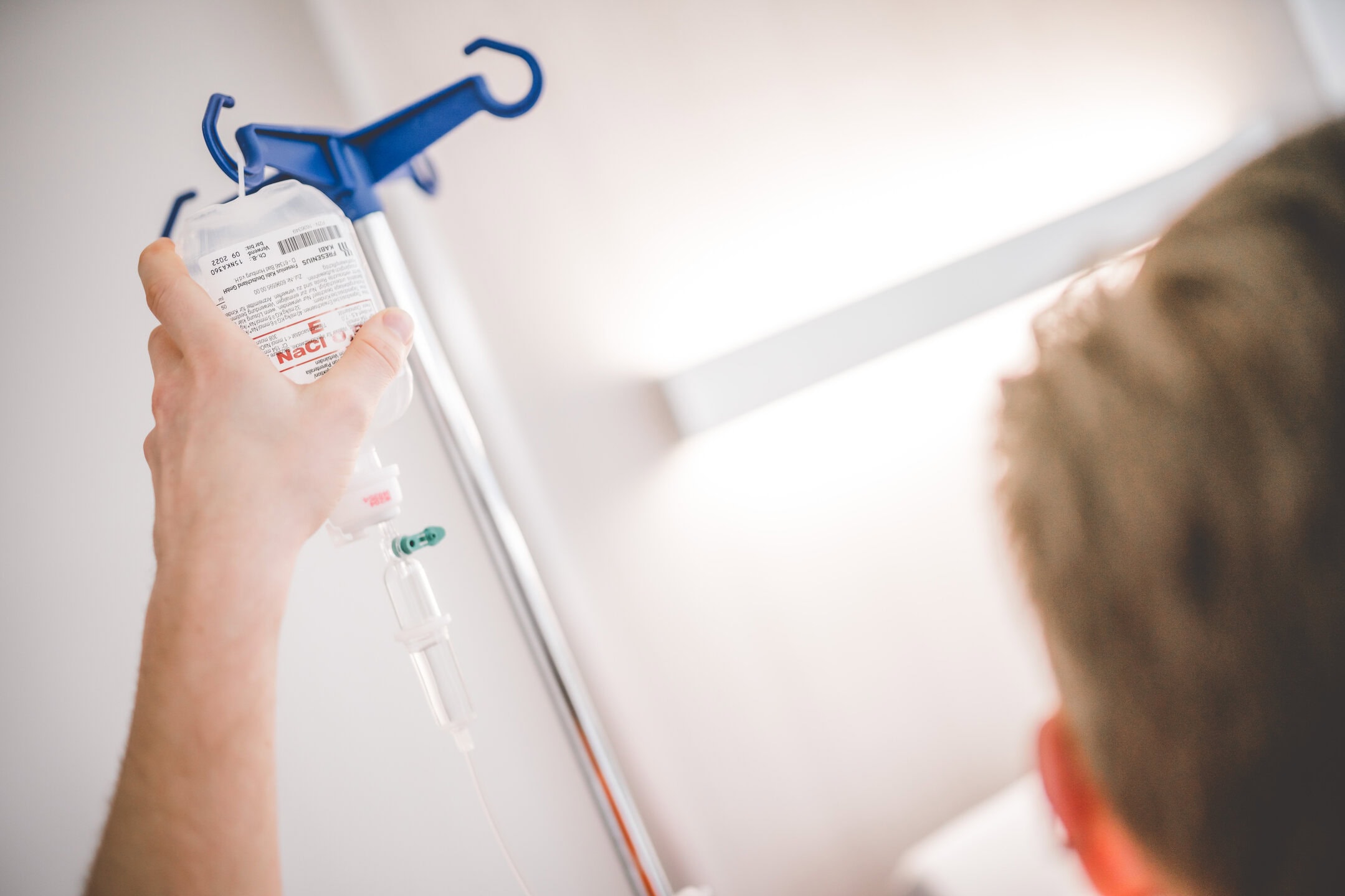 Am Patientenbett wird ein Infusionstropf aufgehängt.