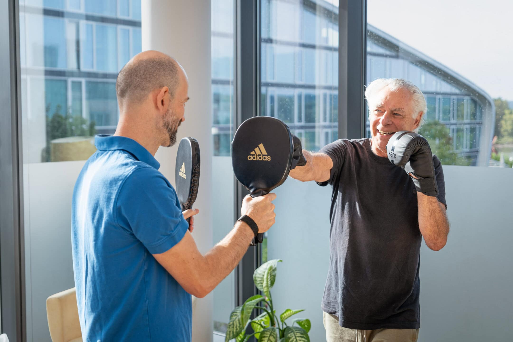 Körpertherapeut beim therapeutischen Boxen mit einem Patienten.
