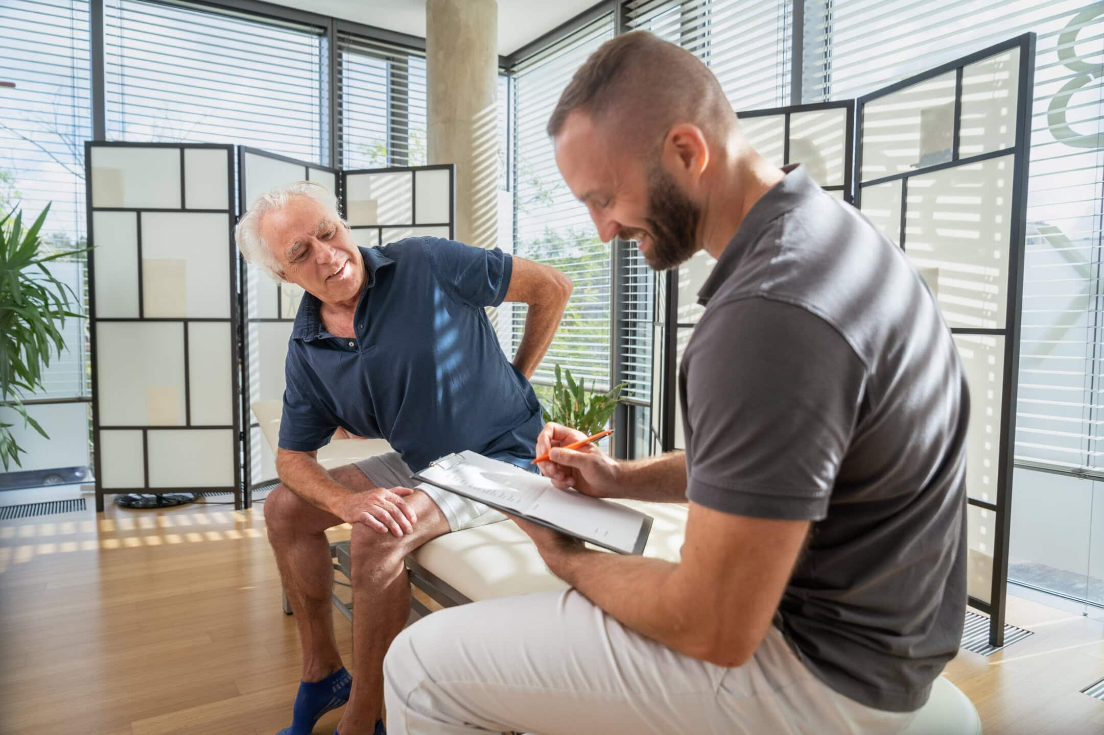 Physiotherapeut in einem Patientengespräch.