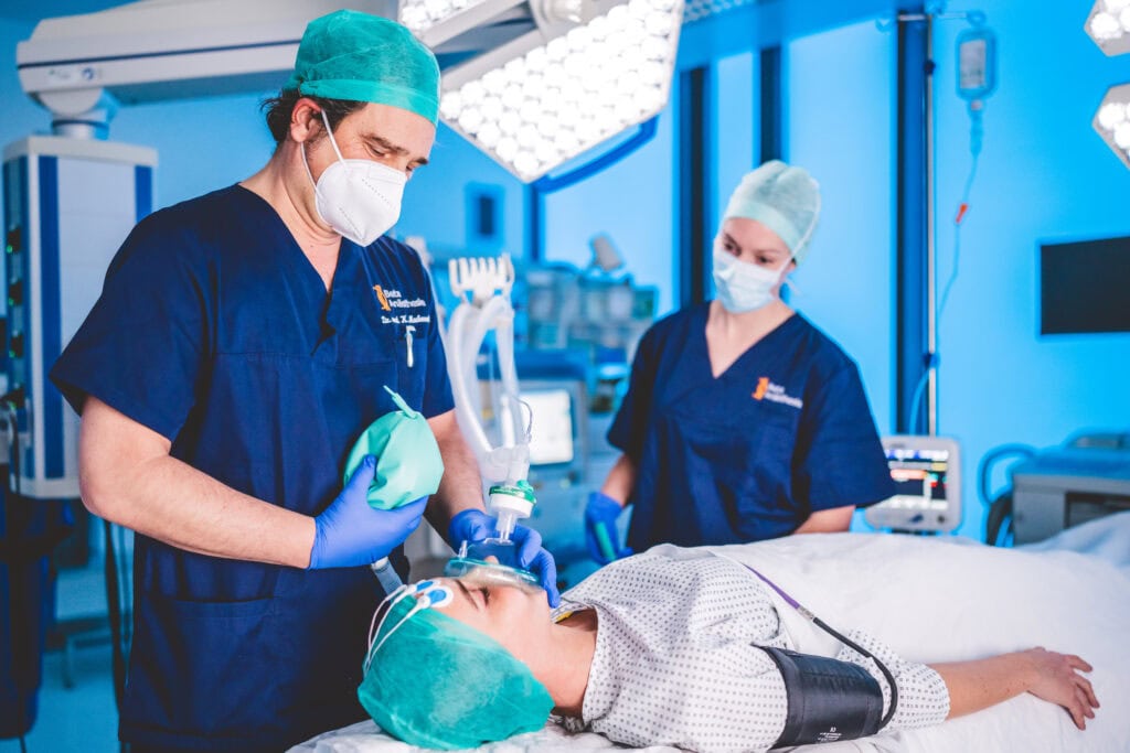 Anästhesist bereitet Patientin auf die Vollnarkose vor.