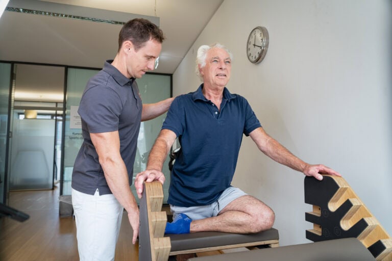 Mann bei der Physiotherapie unter Anleitung des Facharztes in der Beta Klinik Bonn