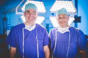 Zwei Chirurgen stehen im OP.